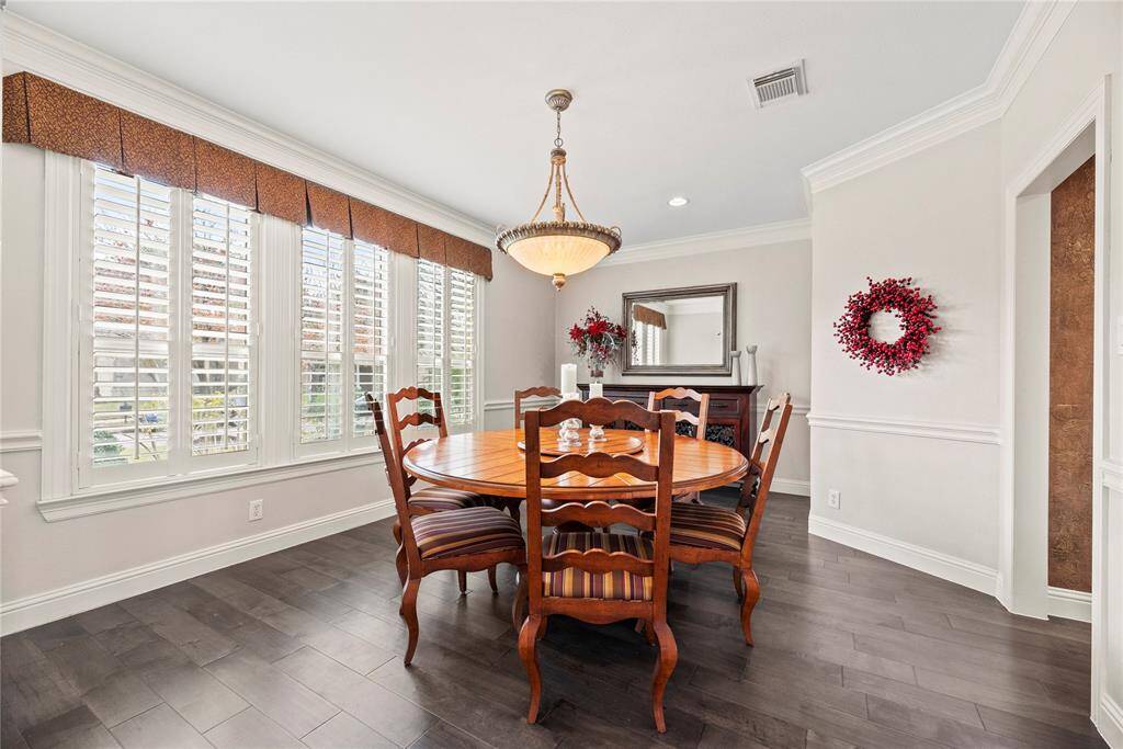 Perfect for entertaining, this dining room has ample space for a large table and sideboard. The crown molding adds the hint of elegance and pairs beautifully with the cool palette.