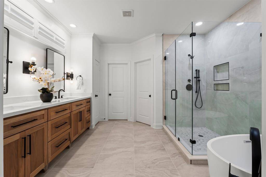 This handsomely renovated master bathroom offers double vanities, an over sized shower and separate soaking tub.