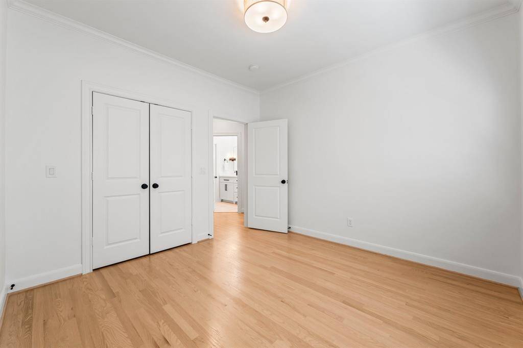 One of two secondary bedrooms with new hardwood flooring and updated lighting.