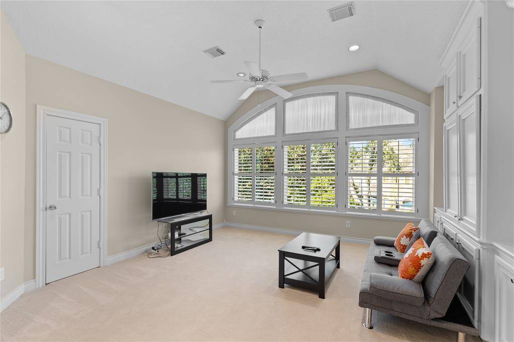 Another view of the game room and a massive plantation shutters windows, making it a bright and inviting space for leisure and activities.