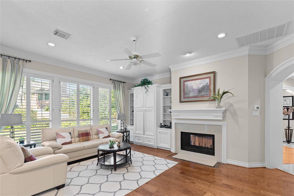 Formal Living area surrounded by a gracious fireplace, a massive plantation shutters over looking into an oversized backyard oasis.