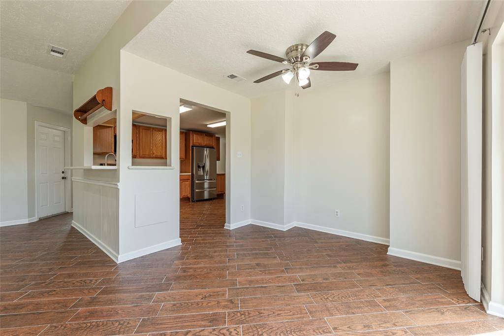 Living room is open to the kitchen and dining areas and features a brick fireplace.