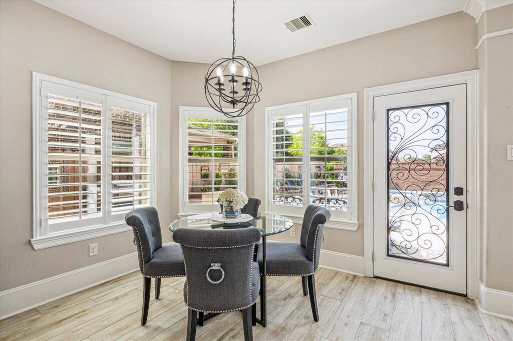 This spacious living room boasts high ceilings, large windows for natural light, and a modern open layout. A cozy gas fireplace, built-in shelves, and an upper-level balcony add charm, while neutral tones and elegant finishes create a warm, inviting atmosphere.