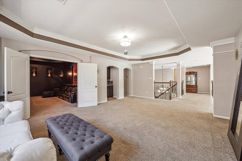 At the top of the stairs, a large game room welcomes you with tray ceilings and crown molding. Double doors open to a private media room, a versatile space for games, dancing, or pursuing your favorite hobbies.