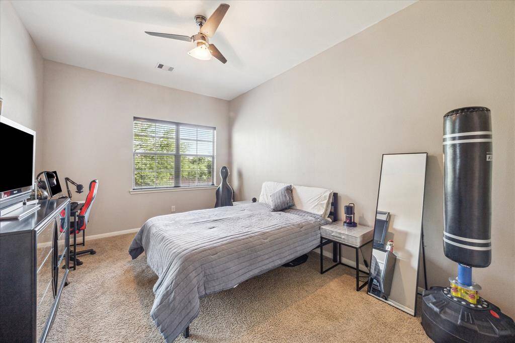 This secondary bedroom features neutral paint, ceiling fan, walk-in closet and attached bathroom vanity with direct access to a shared bathroom.