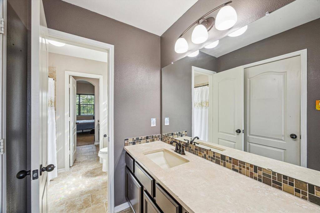 The upstairs secondary bedrooms share a connected bathroom, with each room featuring its own private vanity. This smart layout offers both privacy and functionality—ideal for family or guests.
