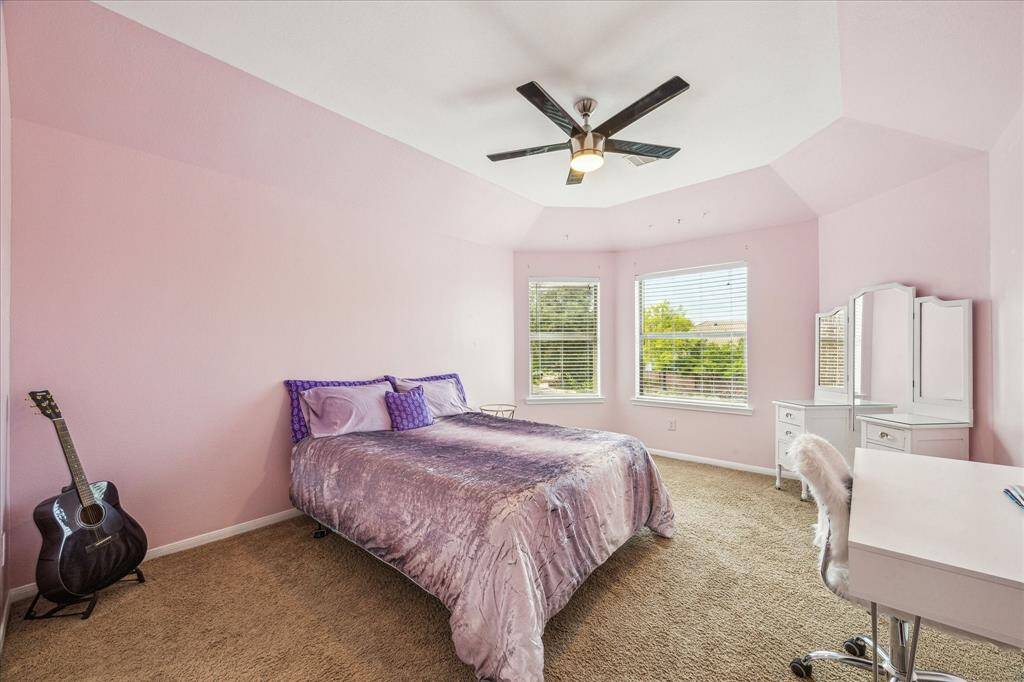 This bright and airy upstairs secondary bedroom is nice sized. It has a stylish ceiling fan and  private vanity, walk-in closet, and direct access to a shared bathroom.