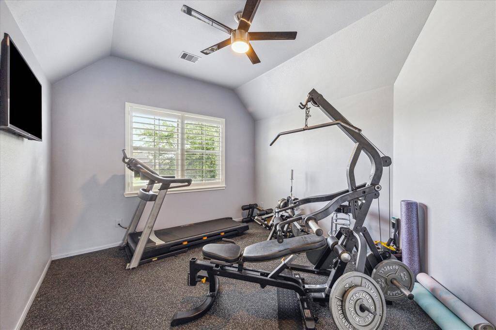 This secondary bedroom is currently set up as a home gym and features cork-like flooring, providing a comfortable and durable surface ideal for workouts or flexible use as a personal space.