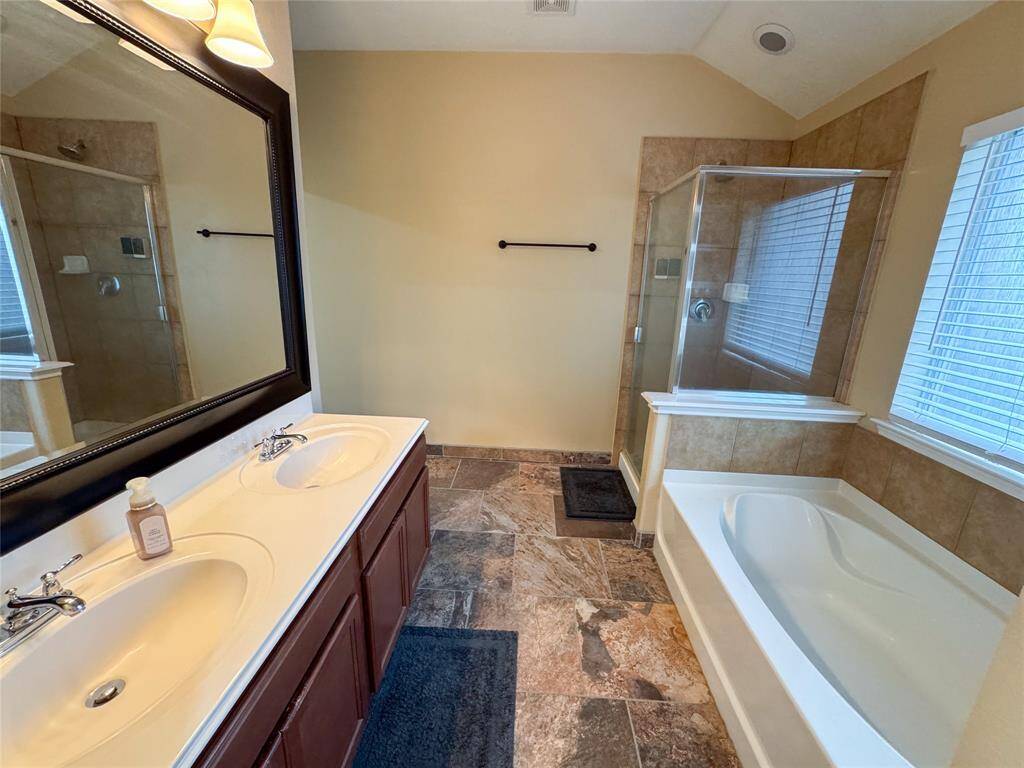 Primary bath with double sinks, separate shower and soaking tub, and private water closet.