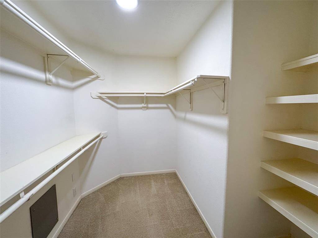Walk-in primary closet with great built in shelving.