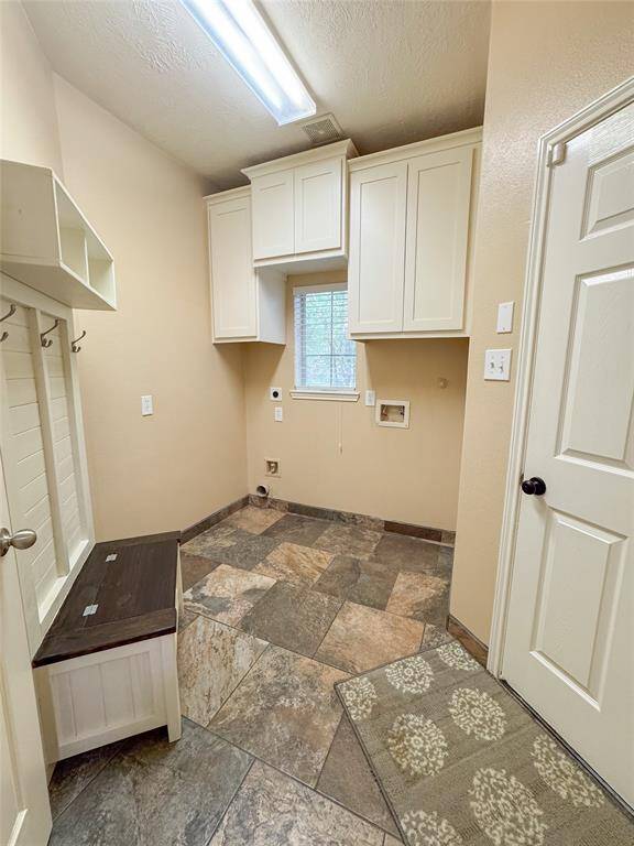 Large laundry room with custom built in cabinets. Home has a large hall closet and nice size coat closet in the hallway to secondary bedrooms.