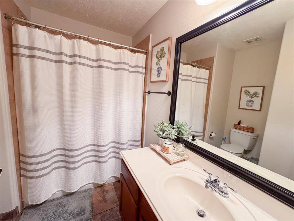 Full bath with tub shower combo and built in shelving (not pictured).