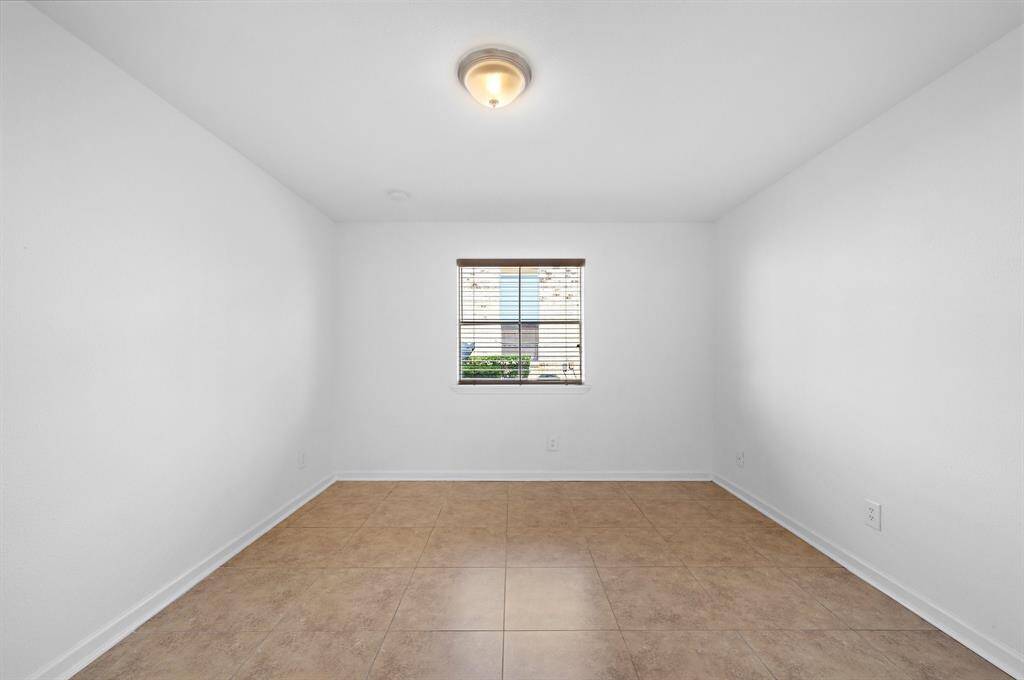 The spare bedroom has Fresh Paint, neutral Ceramic Tile flooring throughout, a Large Window with nice Wooden Blinds that let in lots of natural light when open, Large Walk-in Closet, and modern fixtures and finishes!!