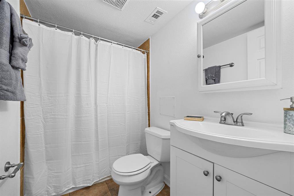 The master bath has Fresh Paint, neutral Ceramic Tile Flooring and Backsplash on Shower/Tub combo, a mirror that doubles as a medicine cabinet, "Hollywood" lighting over a white Wooden Sink Vanity Cabinet, and modern fixtures and finishes!!