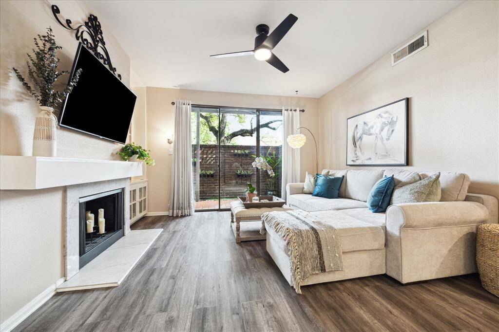 A large light filled living room with a real wood burning fireplace as the focal point, built-in bookshelves and lower cabinet for additional storage, and access to the patio through a glass sliding door, makes this an ideal place to relax.