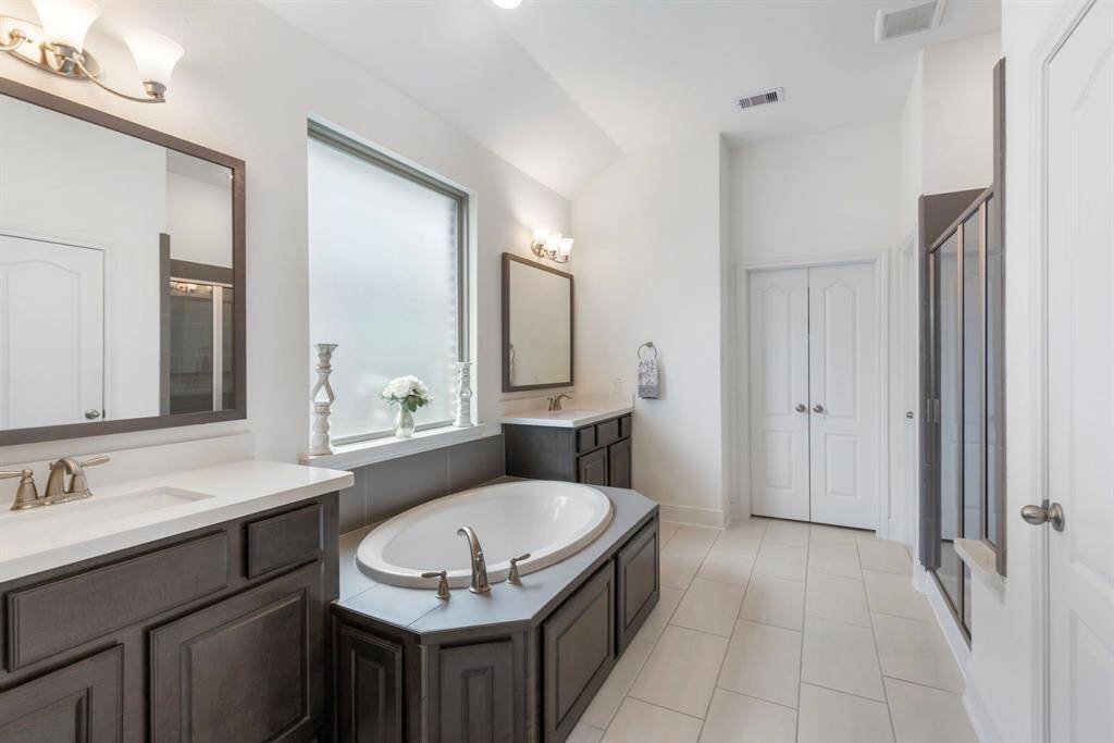 The primary bathroom offers a tranquil retreat with a spacious layout. The separate soaking tub and walk-in shower create a luxurious, spa-like atmosphere where you can unwind after a long day.