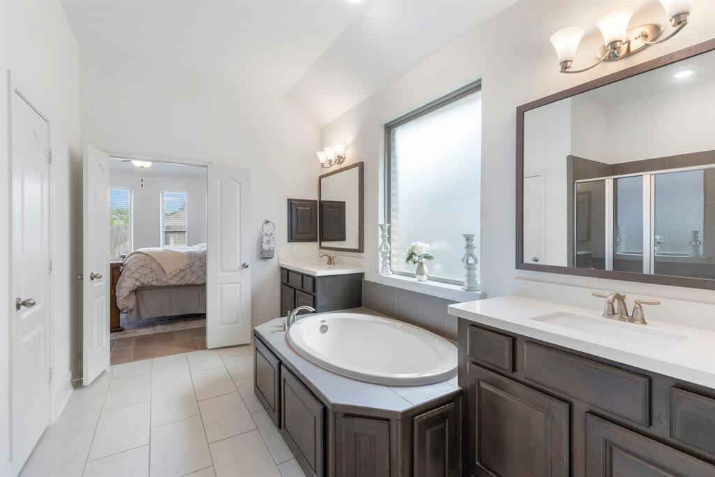 The dual vanities provide ample counter space and storage, offering both convenience and style