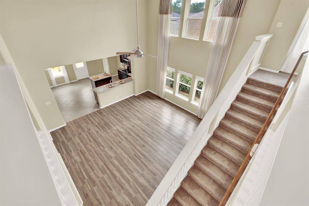 This home offers a sense of openness that’s both inviting and elegant. High, unobstructed ceiling lines and minimal wall interruptions contribute to the home’s spacious character, making each area feel connected yet comfortably distinguished. Expansive windows line the living room, allowing natural light into the space, casting a warm, welcoming glow throughout and enhancing the home’s airy, open atmosphere.