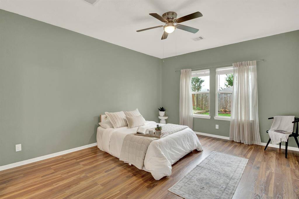The primary bedroom offers a tranquil retreat with dark, richly stained wood floors that add warmth and sophistication to the space.