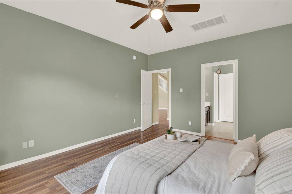 The primary bedroom, thoughtfully located on the downstairs level, offers a sense of privacy and tranquility while maintaining a connection to the rest of the home.