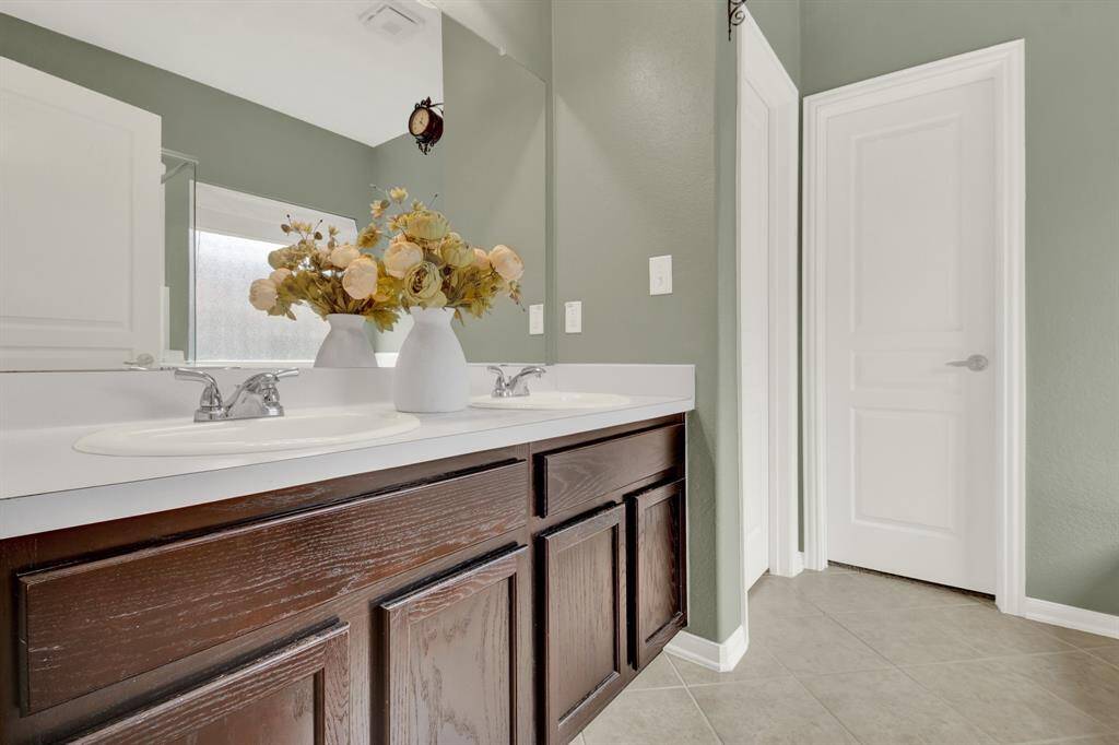 Thoughtfully designed with double sinks for convenience and comfort, the bathroom offers a sense of privacy and relaxation, complementing the restful vibe of the bedroom.