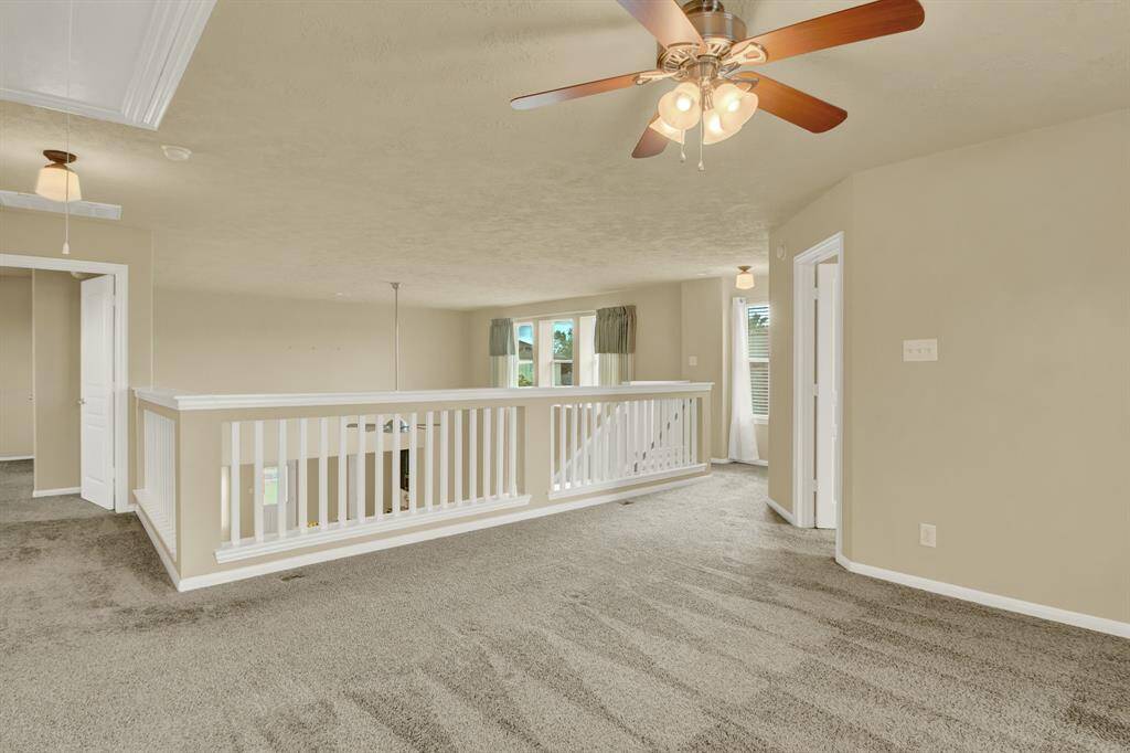 Situated between the three upstairs bedrooms, the loft offers a flexible space that can adapt to a variety of needs from a play area, game room, study nook or media lounge Its central location makes it a natural gathering spot, easily accessible from each bedroom while maintaining a sense of openness. Lined with a distinctive California-style railing, the loft overlooks the lower level, creating a visual connection between floors.