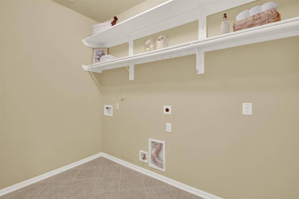 The expansive utility room is designed for both efficiency and organization, offering ample space for laundry tasks while providing practical storage for cleaning supplies, household items. The room’s layout ensures ease of use, with enough room for a washer and dryer and refrigerator.
