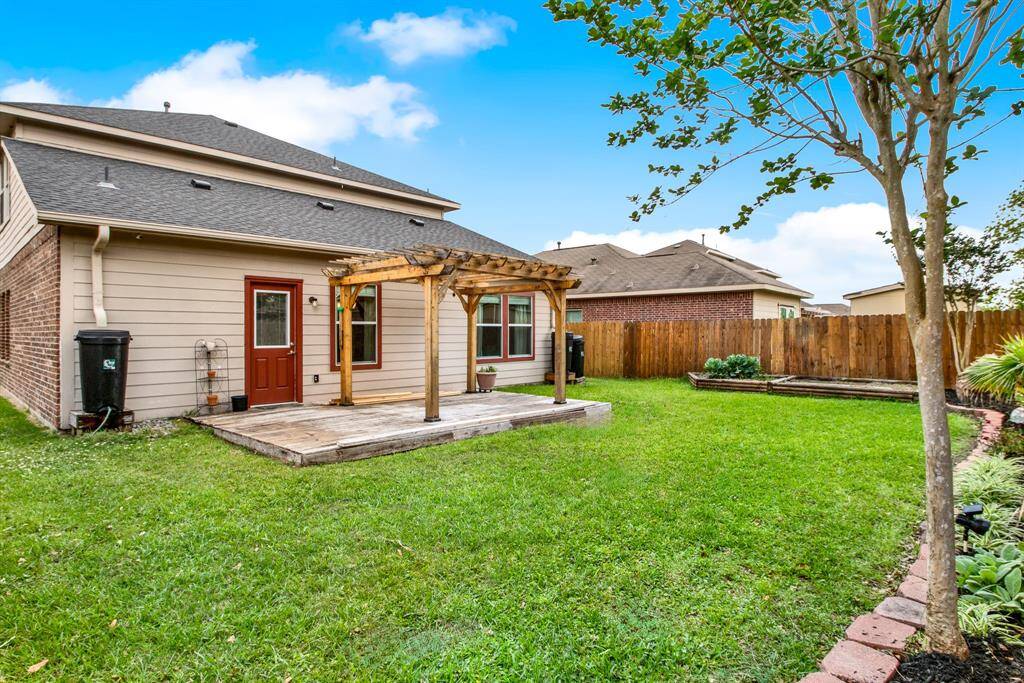 Brick-lined landscaping frames the yard, adding structure and a clean, polished look to the space. This thoughtfully designed outdoor environment creates an inviting backdrop for enjoying the outdoors.