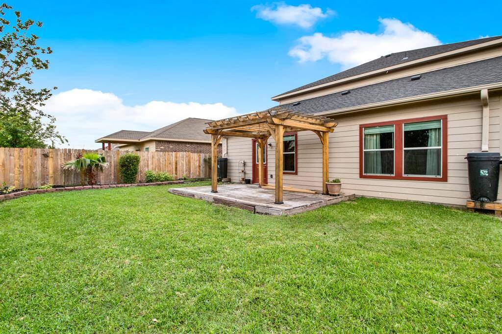 The spacious backyard offers a versatile outdoor space, designed for both relaxation and functionality. A charming pergola provides a shaded area for dining or lounging, creating a comfortable retreat. The deck extends the living area, perfect for enjoying warm evenings or hosting gatherings.