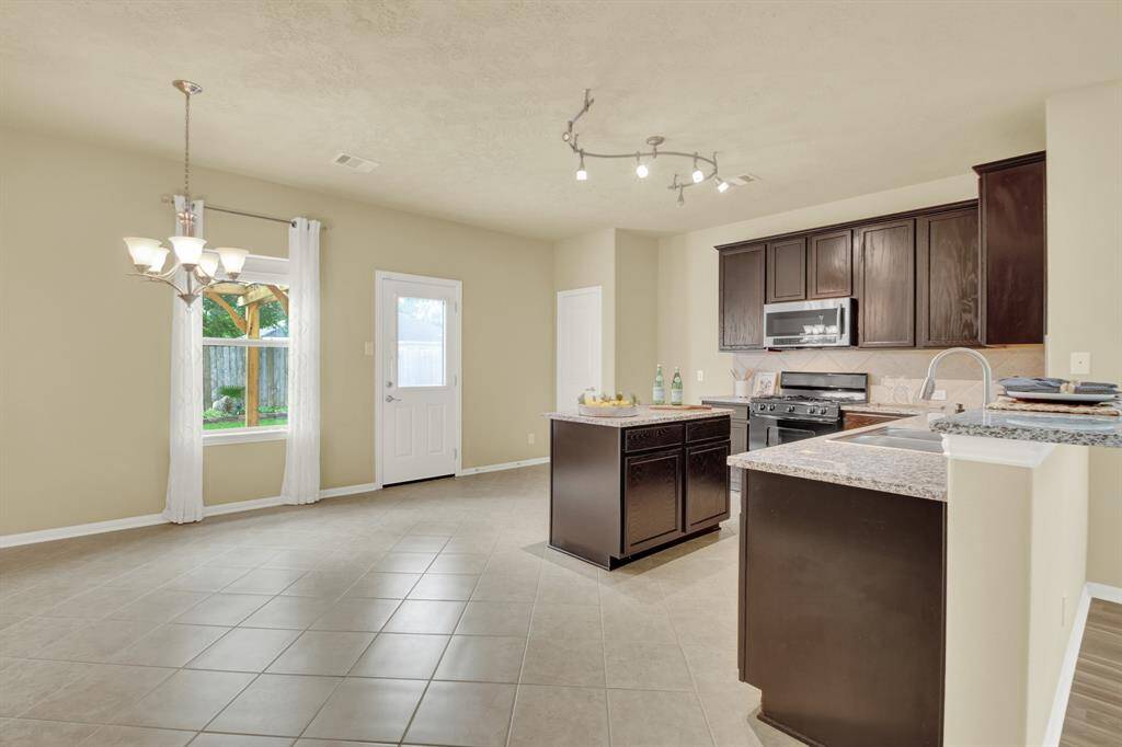 Designed for both everyday functionality and effortless entertaining, this thoughtfully planned kitchen offers a balanced blend of style and practicality. A large center island provides ample space for meal prep or casual dining, while the granite surface adds a polished, durable finish.