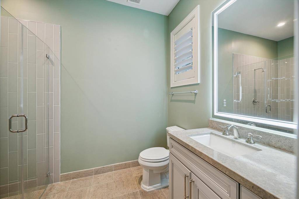 The spacious en-suite bath is designed with elegant fixtures, featuring a sleek shower.