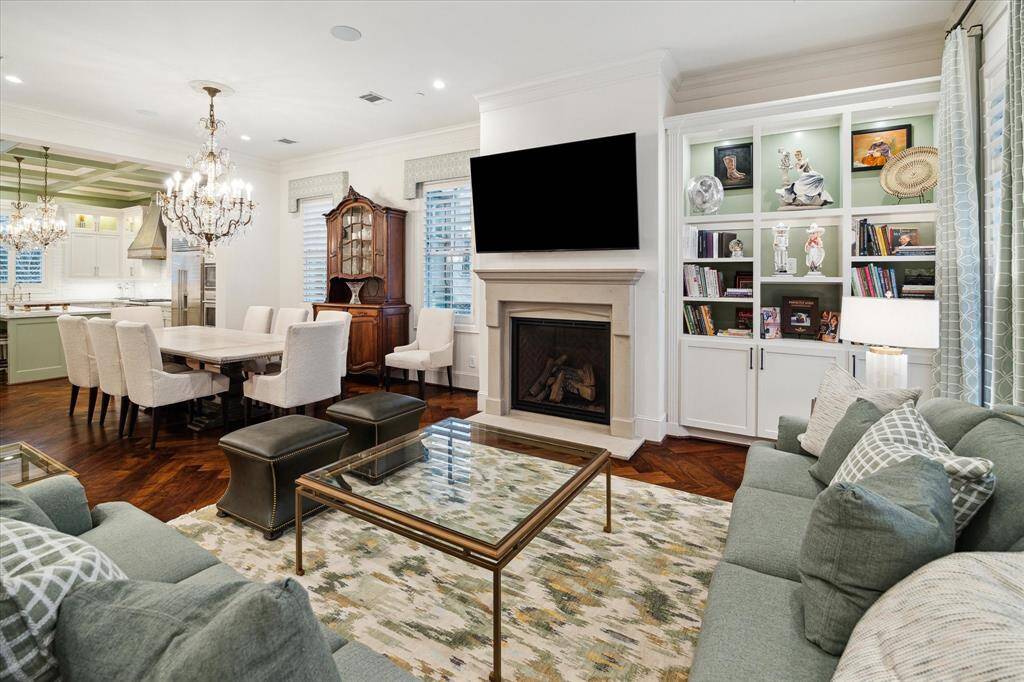 Tailored family room offers plenty of storage for books, electronics, and decor. The sleek fireplace and cabinets frame the space, built-ins keep the room organized and clutter-free.