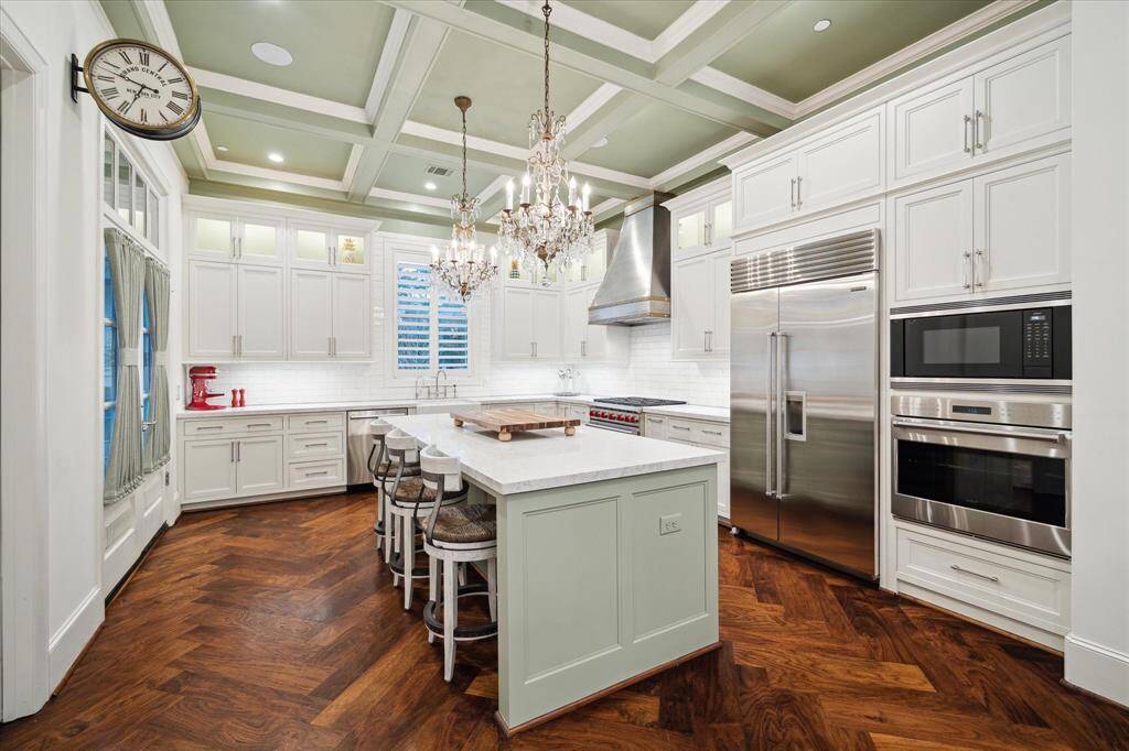 A fantastic view of the chef’s kitchen paired with herringbone wood flooring is absolutely stunning!