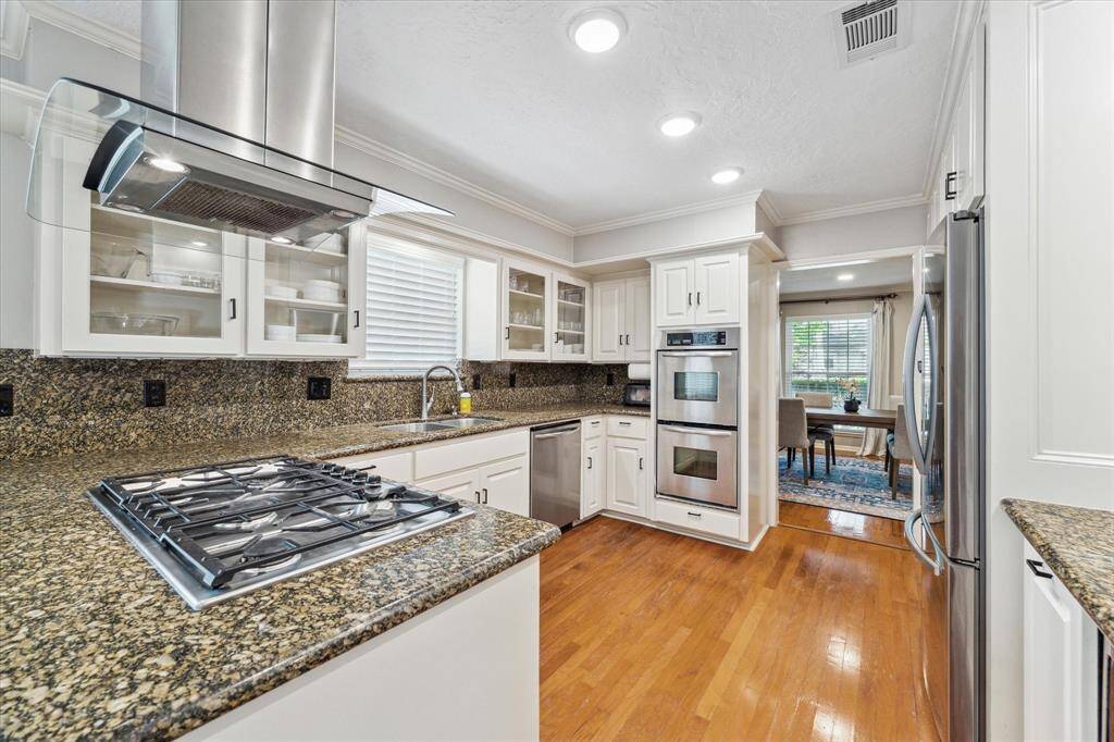 Kitchen boasts gas cooktop, granite counters and double stainless steel ovens