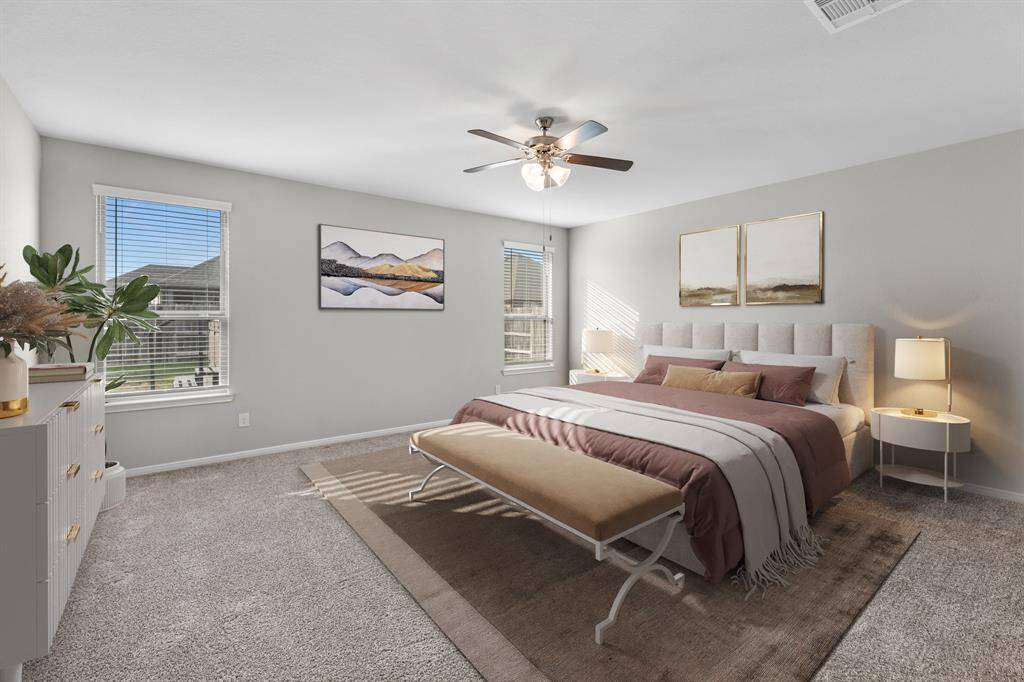 The large primary bedroom, virtually staged to showcase its full potential, is located on the first floor with views of the backyard. Designed with a split floor plan, it offers added privacy by separating it from the other secondary bedroom downstairs.