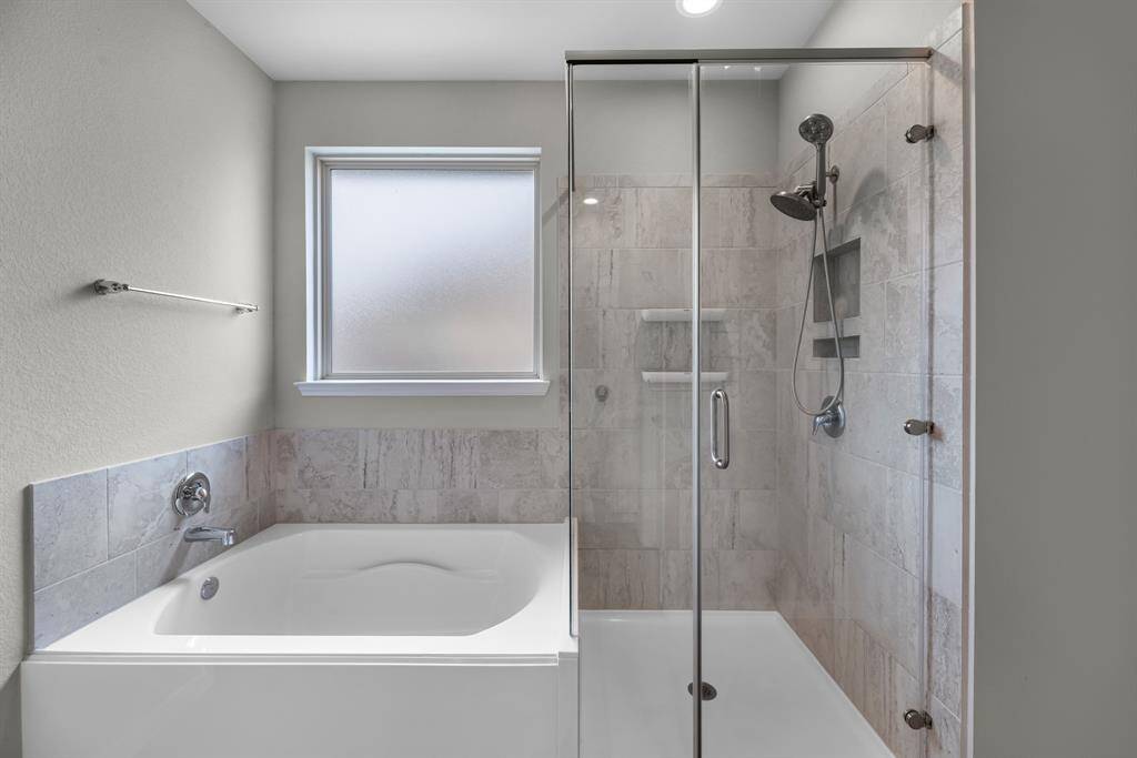 he primary bathroom features a separate large soaking tub and a walk-in shower