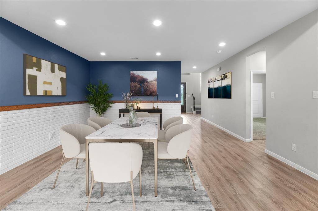 The dining room has been virtually staged to highlight its potential as an elegant entertaining space. Sellers have thoughtfully added a designer brick façade and a neutral navy accent wall, bringing warmth and character to the room with a modern, stylish touch.