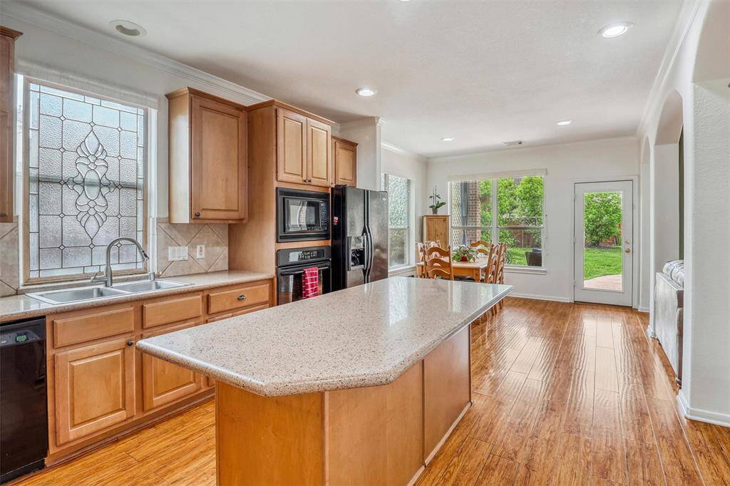 The expansive island kitchen is a true chef’s dream, thoughtfully designed for both culinary creativity and everyday convenience. Gleaming hardwood floors flow throughout the space, complemented by classic crown molding that adds an elegant touch.