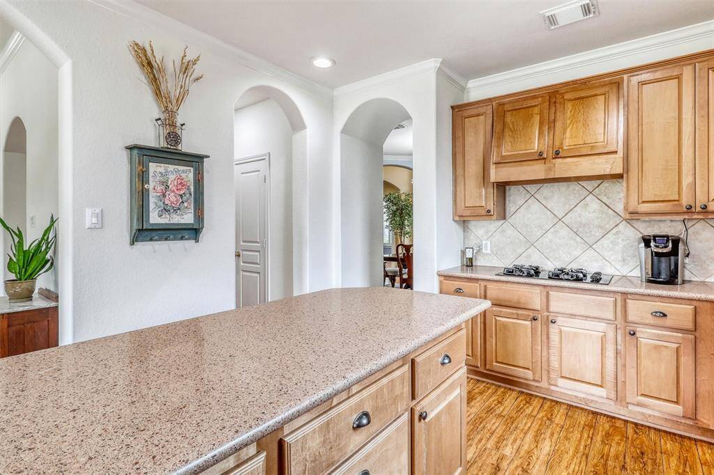 At the heart of the kitchen, a generous island provides ample workspace for meal prep, casual dining, or gathering with guests.