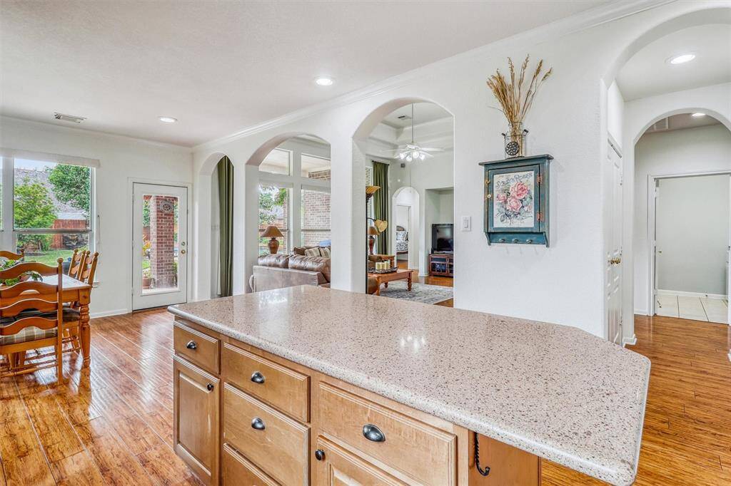 Just off the kitchen, you'll find a bright and open breakfast area—perfect for casual meals or morning coffee. Elegant archways gracefully continue from the kitchen into the inviting family room, creating a seamless and sophisticated flow throughout the living space.
