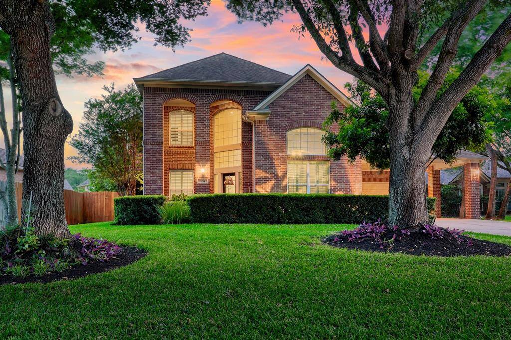 A manicured green lawn, mature trees, and lush landscaping deliver exceptional curb appeal to this 4-bedroom, 3.5-bathroom residence.
