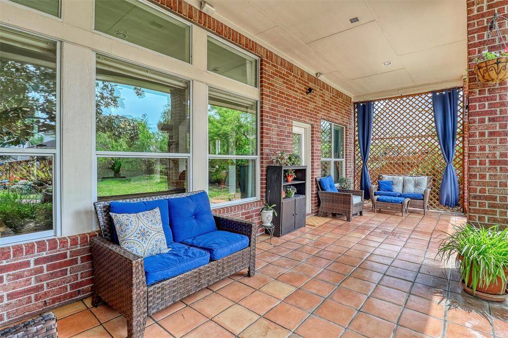 Step outside into your own private backyard paradise, where a vast covered patio with stunning Spanish tile flooring immediately invites you to unwind and enjoy the outdoors in comfort.
