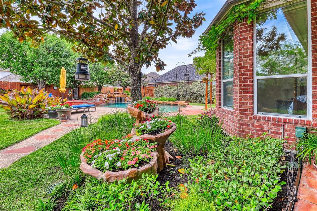 A charming pebblestone walkway winds through lush landscaping, guiding you toward the sparkling pool that serves as the centerpiece of this outdoor retreat.
