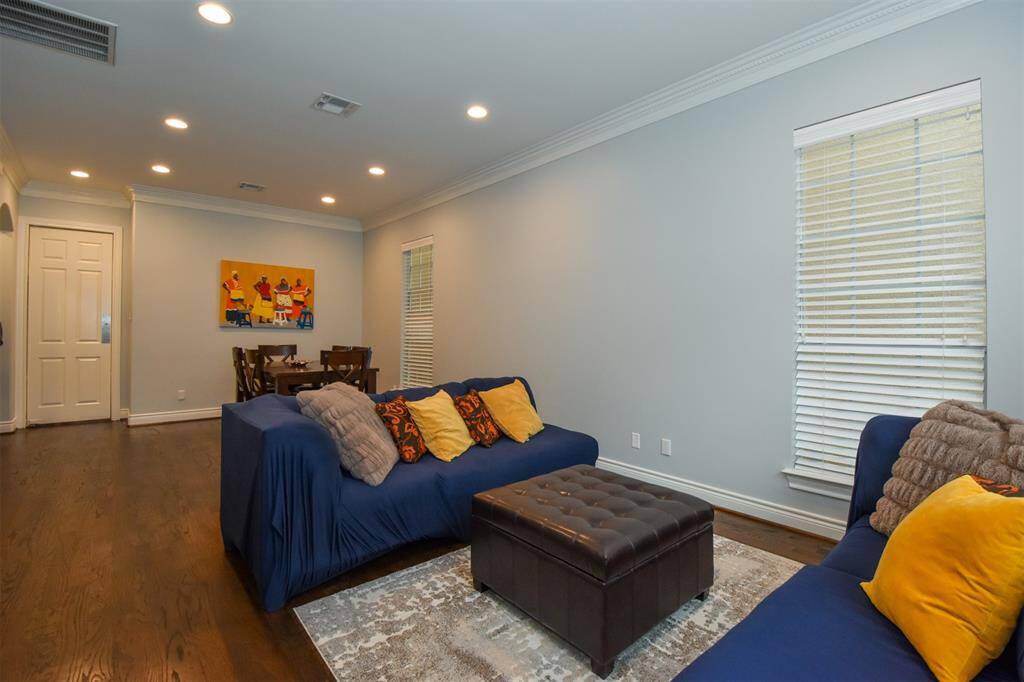Formal living + dining room with hardwood floors, recessed lighting, and a neutral color scheme