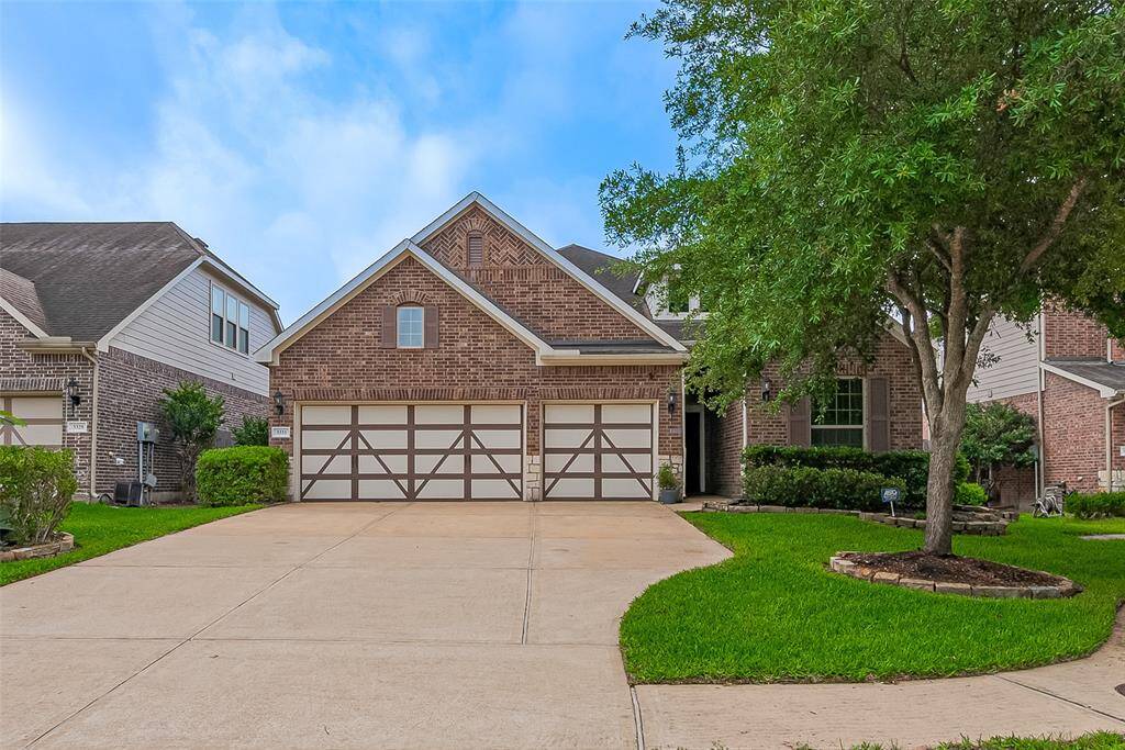 This charming home features a classic brick exterior with a spacious three-car garage. The well-maintained front yard includes lush green grass and a mature tree, offering excellent curb appeal. Ideal for families looking for a welcoming neighborhood setting.