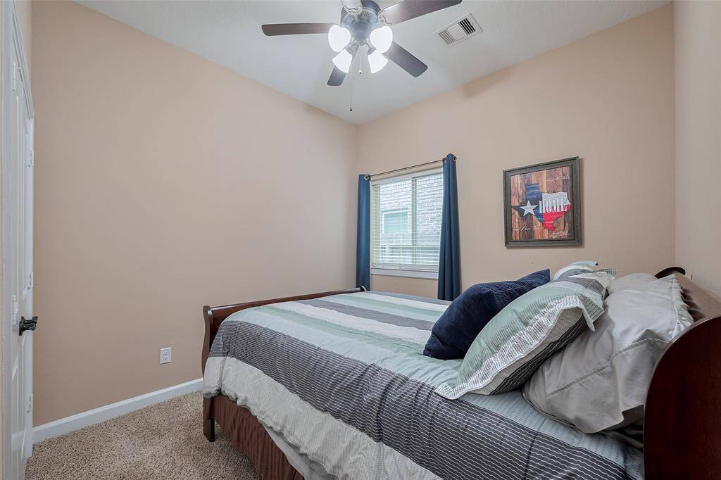 Bedroom 3. This cozy bedroom features neutral walls, a ceiling fan, and a window with natural light.