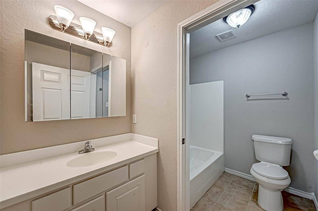 The primary bathroom includes a vanity area separated from the shower/tub combo.
