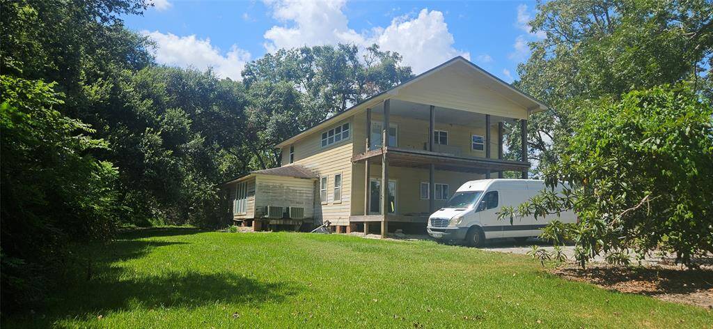 Back of the home. Notice the large back porch off the family room / kitchen area and the balcony off the Primary bedroom suite upstairs.