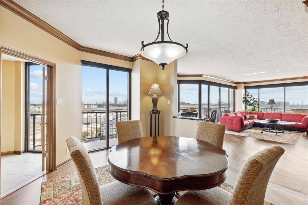 Living room flows seamlessly into a dining room with warm paint and beautiful crown molding.