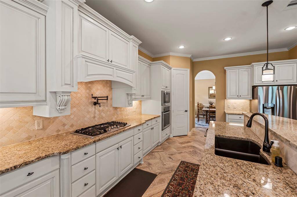 Chef's island kitchen with huge breakfast bar, granite countertops, 5 burner gas cooktop w/ pot filler, tons of cabinets and a walk-in pantry.